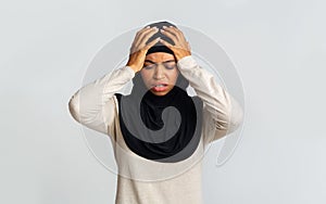 Sick black muslim lady in headscarf touching her head with hands