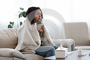 Sick Black Woman Suffering From Flu At Home, Drinking Tea And Resting