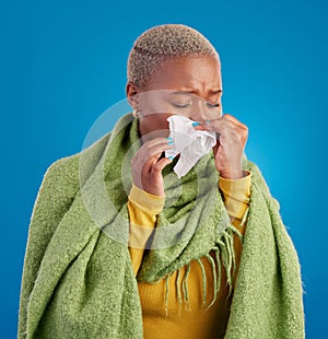 Sick black woman, tissue and blowing nose in studio, blue background or hayfever allergies, cold or winter virus. Female