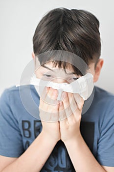 Sick Boy Blowing Nose with Kleenex Tissue