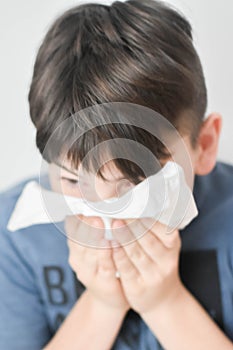 Sick Boy Blowing Nose with Kleenex Tissue