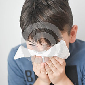 Sick Boy Blowing Nose with Kleenex Tissue