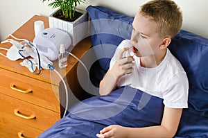 Sick boy breathing through nebulizer, inhaler for treatment prevention, such as, asthma, allergies