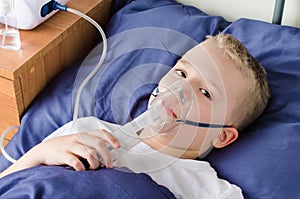 Sick boy breathing through nebulizer, inhaler for treatment prevention, such as coronavirus, asthma, allergies