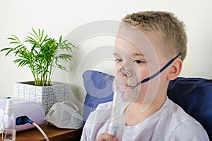 Sick boy breathing through nebulizer, inhaler for treatment prevention, such as coronavirus, asthma, allergies