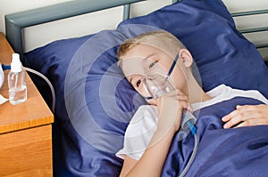 Sick boy breathing through nebulizer, inhaler for treatment prevention, such as coronavirus, asthma, allergies