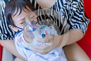 Sick boy inhalation therapy by the mask of inhaler. Baby has asthma and need nebulizations. Patient Boy use inhalation with Nebuli photo