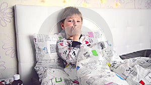 The sick boy lay in bed coughing. The boy coughs in his bed