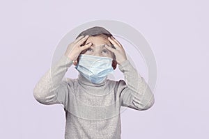 A sick boy in surgical mask haves headache