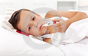 Sick boy with thermometer taking temperature