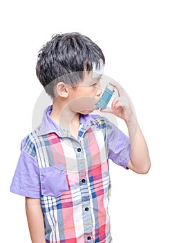 Sick boy using inhaler for asthma