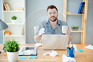 Sick businessman with grippe sitting in office and holding a cup of tea