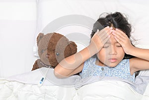 Sick child. Asian little girl headache and  lying on bed