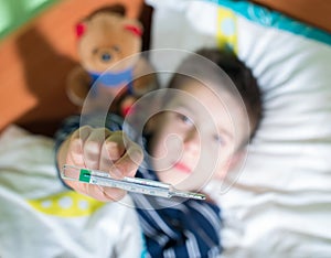 Sick child in bed with teddy bear