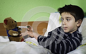 Sick child in bed with teddy bear