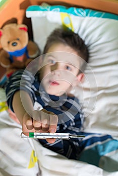 Sick child in bed with teddy bear