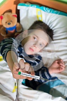 Sick child in bed with teddy bear