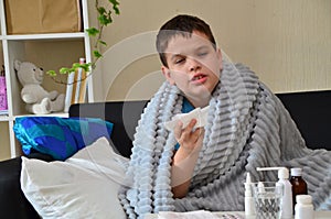 Sick child boy lying in bed with a fever, resting at home. a boy with a cold, treated. medicines, throat nose spray