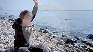 Sick child boy uses nebulizer inhaler mask to treatment of asthma on seaside.