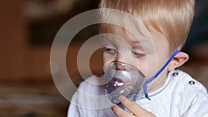 Sick child breathes through nebulizer, close-up.