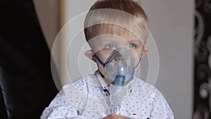 Sick child breathes through nebulizer, close-up.