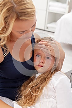 Sick child comforted by mother photo