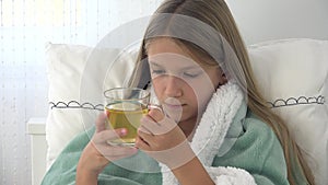 Sick child drinking tea, ill kid in bed, suffering girl, patient in hospital