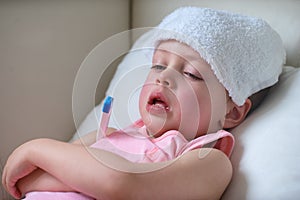 Sick child with high fever laying in bed