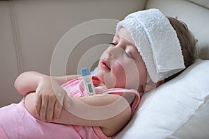 Sick child with high fever laying in bed photo