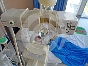 Sick child lying in a hospital with IV