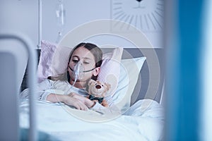Sick child with oxygen mask photo