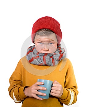 Sick child in warm clothes isolated on white background. Toddler boy in scarf and hat with cup. Illness child. Boy