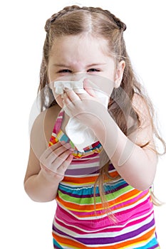 Sick child wiping or cleaning nose with tissue