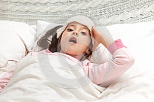 Sick cold little child girl lies in bed