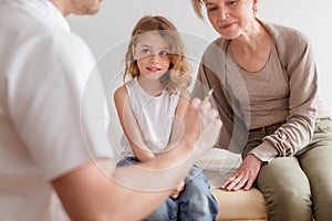 Sick cute little boy with flu at pediatrician`s office with his loving mother