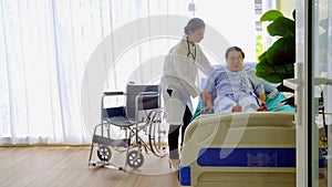 Sick elderly asian senior man resting in hospital bed with the doctor suggestion near the bed.