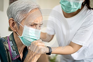 Sick elderly woman with coughing and fever,risk symptoms of flu,pandemic of Covid-19, asian daughter wearing protective mask to