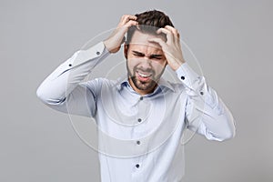 Sick exhausted young unshaven business man in light shirt posing isolated on grey wall background. Achievement career