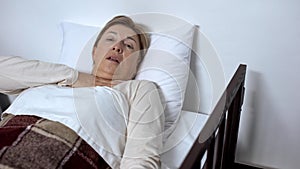 Sick female in bed hardly breathing, suffering suffocation, asthma disease