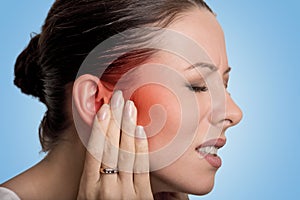 Sick female having ear pain touching her painful head