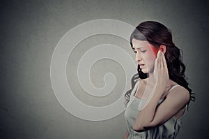 Sick female having ear pain touching her painful head temple colored in red