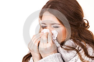 Sick freezing woman sneezing in tissue