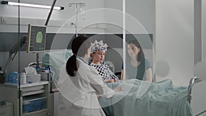 Sick girl child patient wearing egg headset with sensors