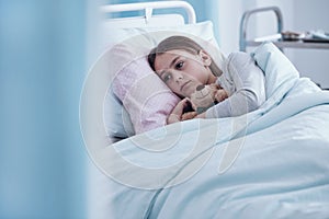 Sick girl in hospital bed photo