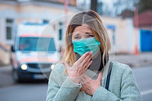 Sick girl wearing surgery medical mask feeling ill being hit by the coronavirus