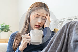 Sick, hurt or pain asian young woman, girl sore throat with glass, mug of warm water, headache have a fever, flu in weakness,