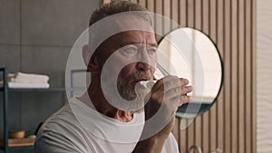 Sick ill old Caucasian man drink remedy vitamin complex in morning middle-aged senior mature male pensioner medicine