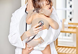 Sick kid, pediatrician and baby with stethoscope for check up, healthcare and illness in family clinic. Child, female