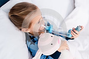 Sick kid using inhaler with spacer