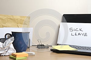 Sick leave message left on a messy office desk